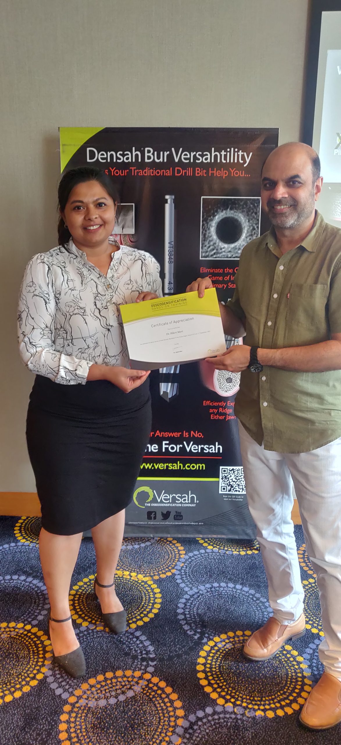 Professional photograph of Dr. Hileri Mori receiving certification after completing advanced implant dentistry and osseodensification training.